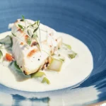A beautifully plated Mary Berry Chicken Supreme dish with tender chicken breasts in a creamy white wine sauce, garnished with fresh parsley.